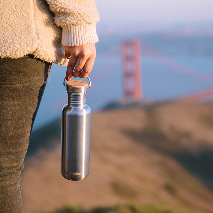 27oz-reflect-with-bamboo-cap-x2 K27SSLRF-BS-BAMBOO_reflect_bottle_bridge_lifestyle.jpg
